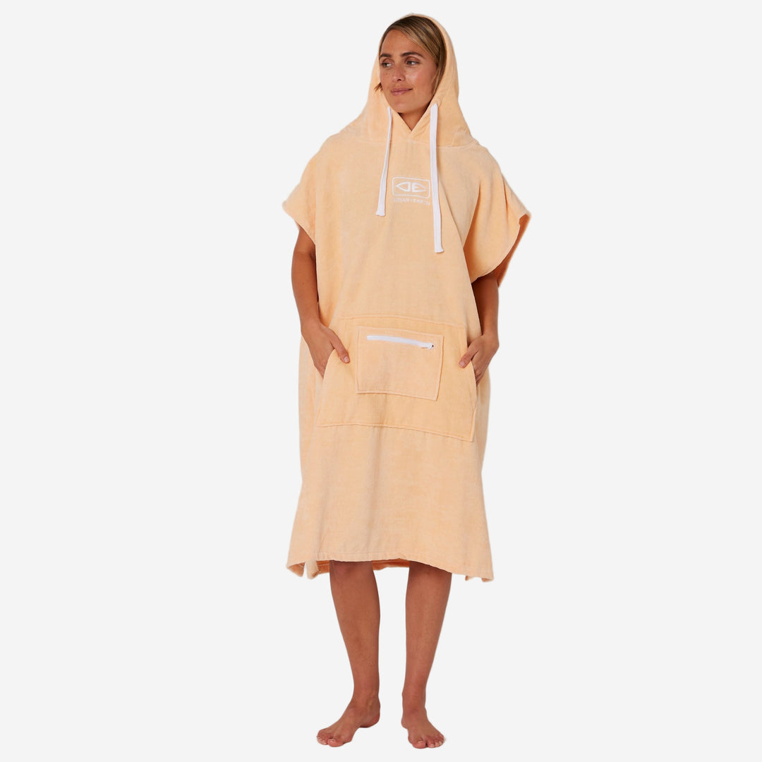 Person wearing a peach-colored hooded towel on a plain background