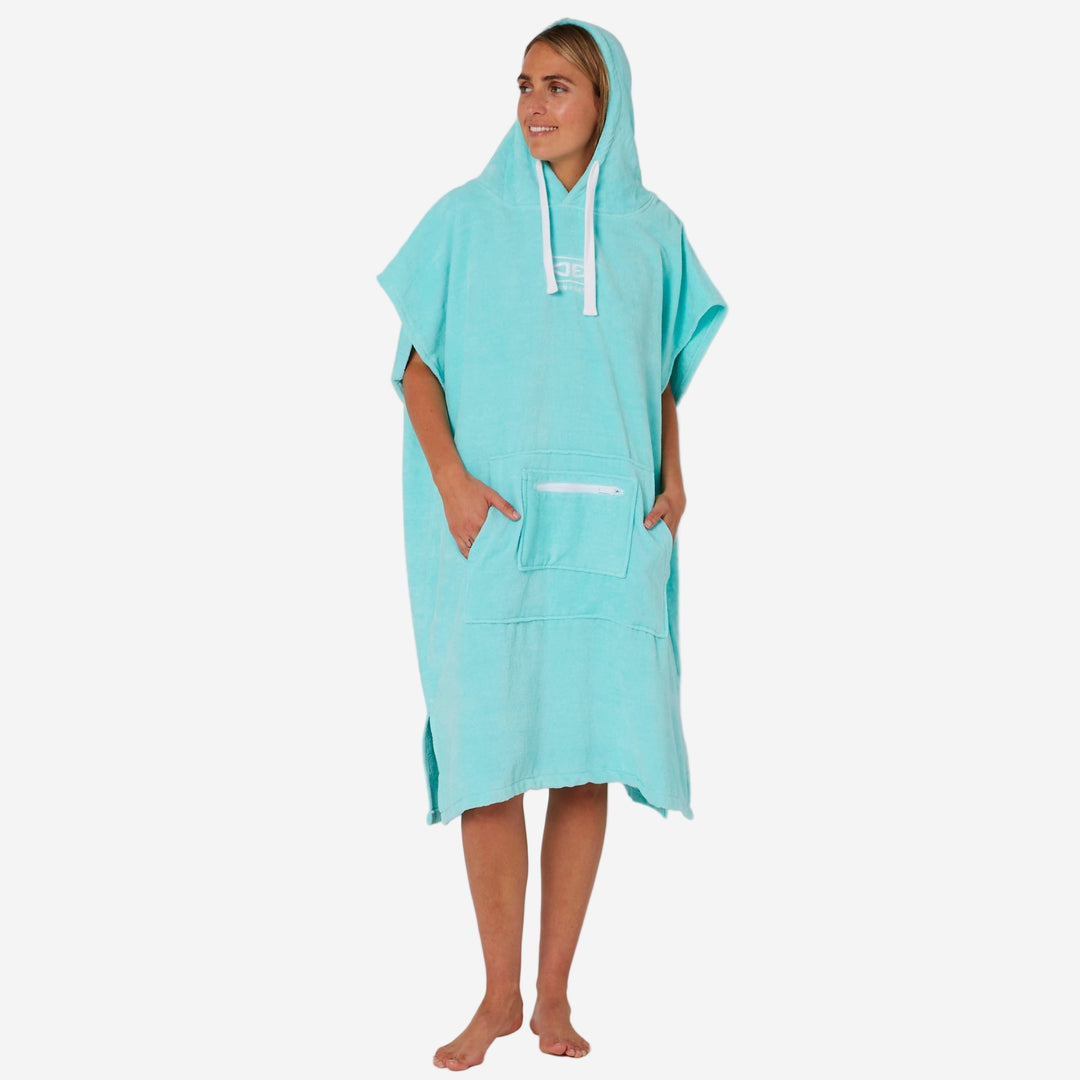 Person wearing a turquoise hooded towel on a plain background