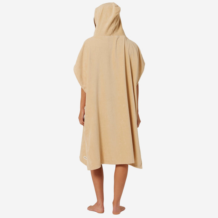 Person wearing a beige hooded towel on a plain background