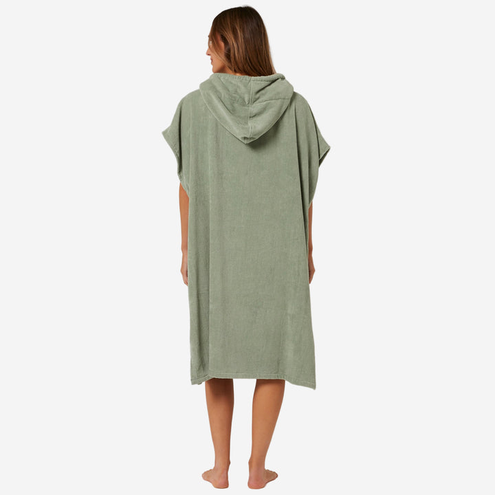 Person wearing a green hooded towel on a plain background