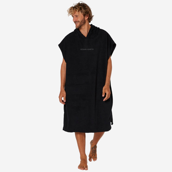 Man wearing a black hooded towel with 'OCEAN & Earth' branding on a white background