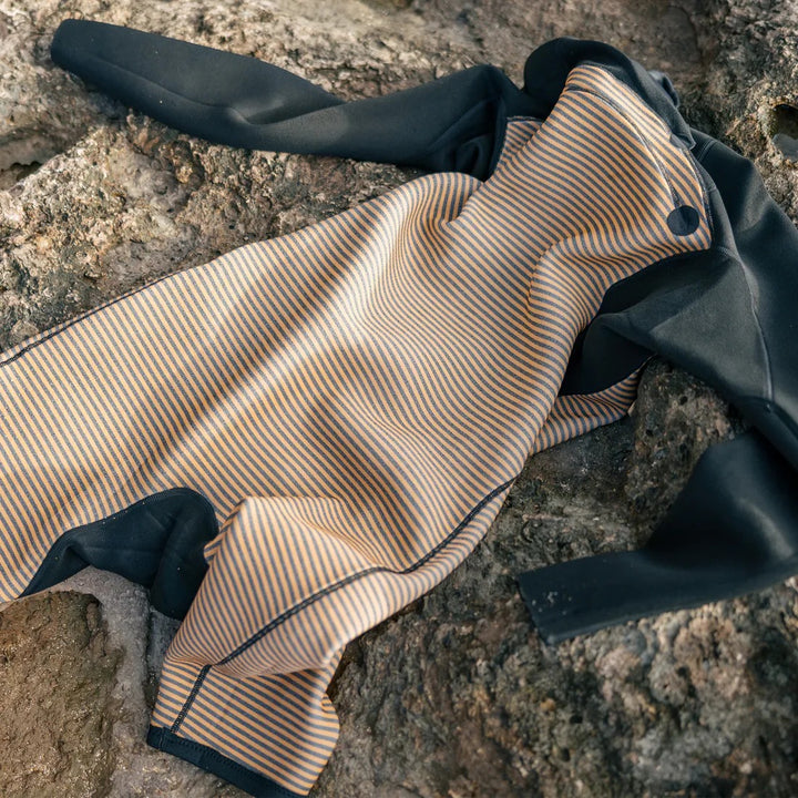 Folded fabric with beige and black stripes on a stone surface